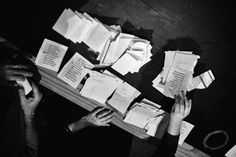 several people are sitting at a table covered with papers