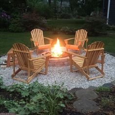 a fire pit with chairs around it in the middle of some gravel and rocks,