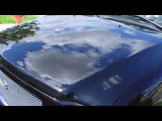 the hood of a car with clouds reflected in it