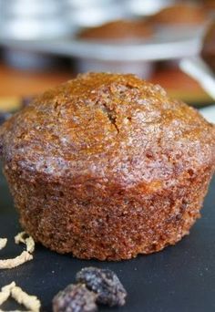 a muffin sitting on top of a black plate next to some raisins