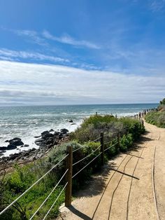 a path leading to the beach with people walking on it