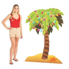 a woman standing next to a cutout of a palm tree with lights on it