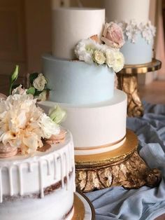 three tiered wedding cakes with flowers on each one and gold trim around the edges