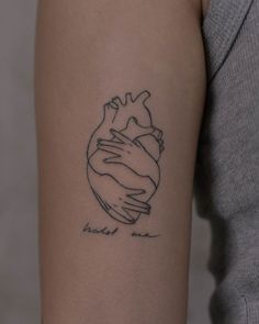 a woman's arm with a heart tattoo on it