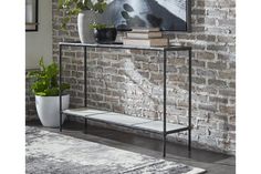 a black and white shelf next to a brick wall with potted plants on it