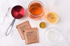 the ingredients to make an iced tea are laid out on a marble counter top, including lemons and sugar