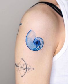 a person with a tattoo on their arm has a blue nautire in the middle