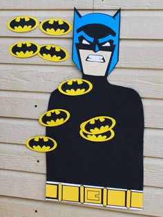 a batman cut out on the side of a building with some magnets attached to it