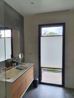 a bathroom with a sink, mirror and sliding glass door that leads to the outside