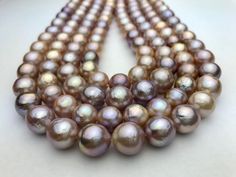 A strand of 10 to 11 mm beautiful round/near Edison pearls AA2 quality round pink and multicolor (pink, peach, cream). Fresh water Edison pearls. Natural colors. 37-40 pearls per strand. About $5 per pearl! We ship within 1-3 days of receiving your order from Hawaii by First Class Airmail. Shipping to the mainland USA usually takes 3 to 5 days. Shipping to anywhere in Hawaii usually takes 1 to 2 days. Shipping international usually takes about 1 week but can take up to several weeks depending on destination. All our pearl pictures were taken with our Samsung camera. We try and give you the best representation of what the pearls look like in person.  These pearls are grade A+ following the pearl grading scale from AAA, AA, A. None of these pearls have been treated in any way. We buy directl Pink High Luster Round Pearl Necklace, Pink High Luster Pearl Necklace, Pearl Pictures, Grading Scale, Cream Fresh, Samsung Camera, 5 Dollar, Kona Coffee, Peach Cream