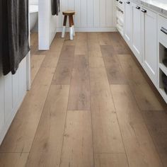 a kitchen with white cabinets and wood floors