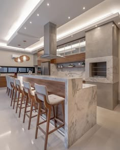 a kitchen with marble counter tops and bar stools in front of an oven that is built into the wall