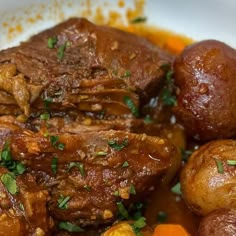 some meat and potatoes in a white bowl