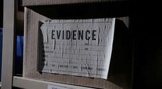 a piece of paper with the word evidence taped to it in front of a computer monitor