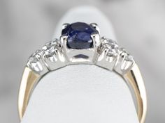 This weighty engagement ring is a wonderful combination of platinum and 14 karat gold, with a polished shine and sleek lines. Balanced on the hand and substantial without being overwhelming, this is a favorite style of setting for engagement rings! Rather than a diamond, we've set this engagement ring with a beautiful sapphire. From our own collection of hand-chosen stones, this sapphire is of exceptional quality. The color is a deep, cornflower blue, with bright flashes radiating from the polis Classic Sapphire Ring With Vvs Clarity For Anniversary, Classic Round Sapphire Ring With Tension Setting, Classic Sapphire Ring With Polished Finish, Classic White Gold Sapphire Ring, Classic Sapphire Diamond Ring With Round Band, Classic Diamond Cut Sapphire Promise Ring, Classic Sapphire Ring With Round Band For Anniversary, Classic White Gold Sapphire Ring For Anniversary, Classic Sapphire Solitaire Wedding Ring