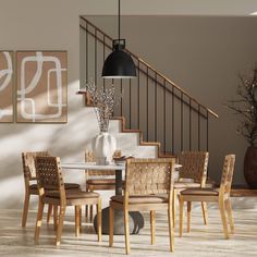 a dining room table with chairs and a vase on top of it next to stairs