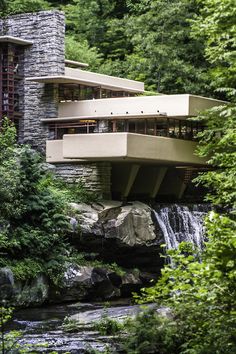 people standing on the side of a building next to a waterfall