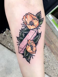 a woman's leg with an orange flower on it and a pink ribbon in the middle