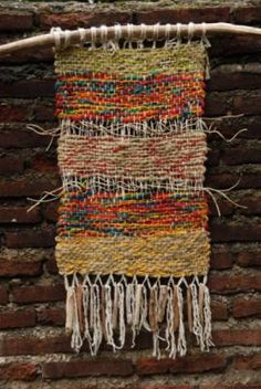 a woven wall hanging on a brick wall