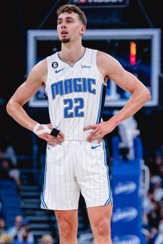 a basketball player standing on the court with his hands on his hips