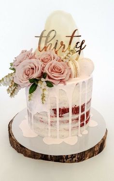 the cake is decorated with pink roses and white icing on it's side