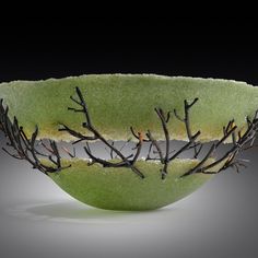 a green bowl with branches in it