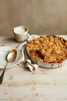 a pie sitting on top of a white plate next to a cup and saucer