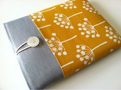 an orange and gray book with white flowers on it