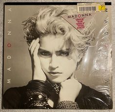 madonna album cover with blonde hair and black leather gloves on the front, sitting on a carpeted floor