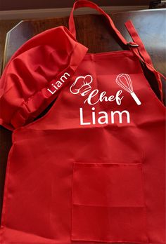 a red apron with the words learn to cook and an image of a whisk on it