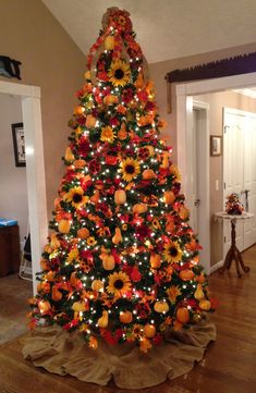 a decorated christmas tree with sunflowers and lights