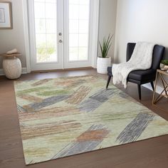 a living room area with a chair and rug on the hardwood floor next to a door