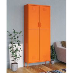 an orange cabinet in a living room next to a couch and potted plant on the floor