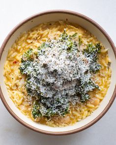 a bowl filled with pasta and cheese covered in parmesan sprinkles