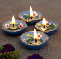 four small blue candles sitting on top of a table