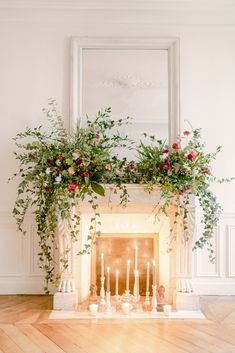 a fireplace decorated with greenery and candles