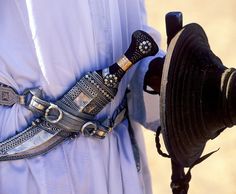 a close up of a person wearing a hat and holding a large metal object in his hand