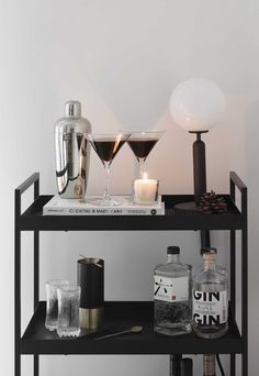 a black shelf with drinks and glasses on it