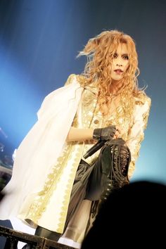 a woman in white and gold outfit on stage