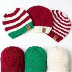 three knitted beanies and two balls of yarn