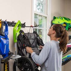 a woman is looking at some toys in a room full of children's bikes