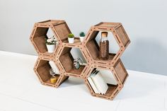 the shelves are made out of hexagonal wooden pieces and have books on them