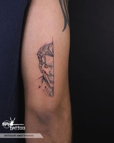 a man's arm with a tattoo on it that has a drawing of a face