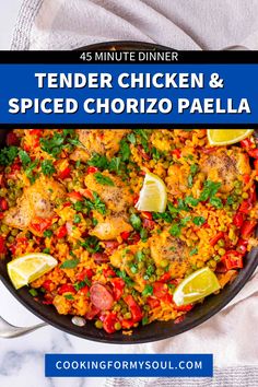 chicken and spiced chorizo paella in a skillet with lemon wedges