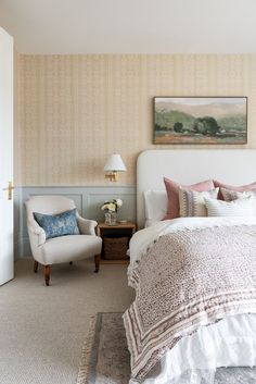 a bedroom with a bed, chair and painting on the wall