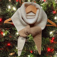 an ornament hanging from a christmas tree with a scarf on it's head