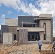 a man walking in front of a building under construction