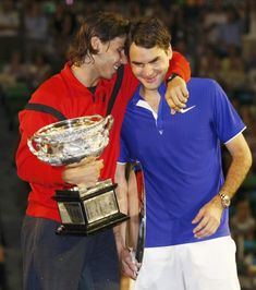 two tennis players are hugging each other and holding the trophy in front of their faces