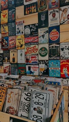 an assortment of beer signs on display in a store window with wooden crates and shelves