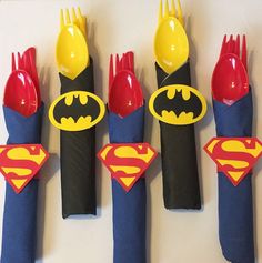 four plastic utensils with batman and superman logos on them